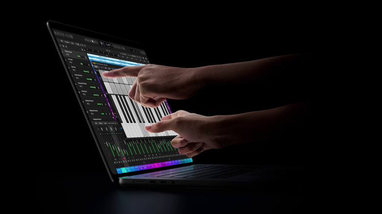 MacBook Pro 화면에서 가상 피아노를 연주하는 사람.