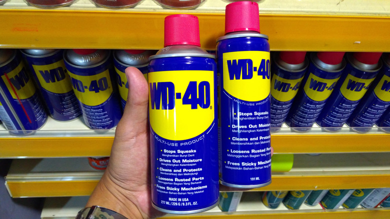 WD-40 병을 들고 있는 손.